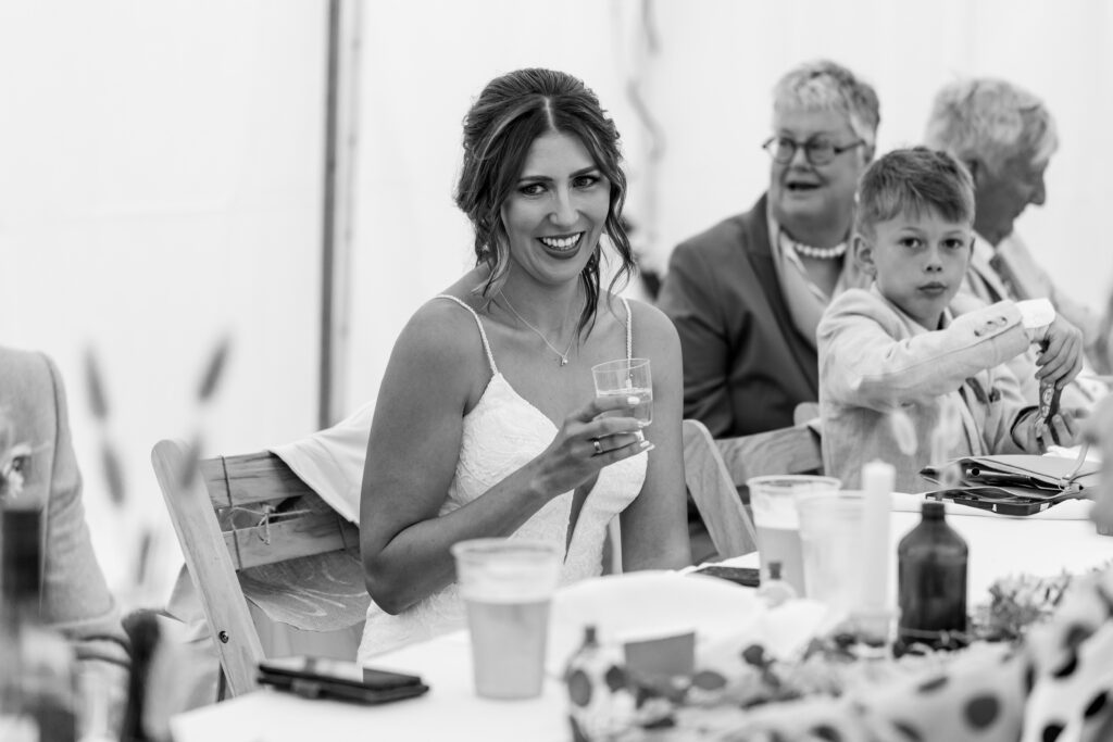 Brides smiling reactions during wedding speeches at a Suffolk wedding venue 